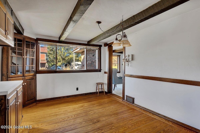 interior space featuring light hardwood / wood-style floors and beamed ceiling