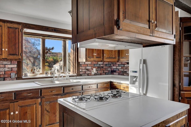 kitchen with sink, decorative backsplash, and white appliances