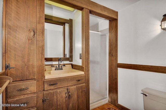 bathroom with vanity, tile patterned floors, toilet, and walk in shower