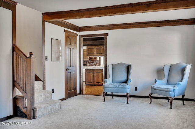 sitting room with light carpet and beam ceiling