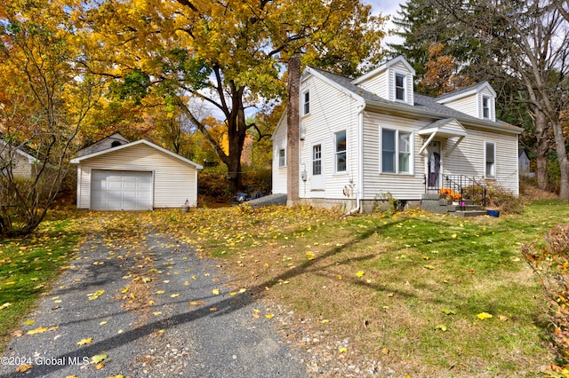 view of front of home with a garage, a front lawn, and an outbuilding