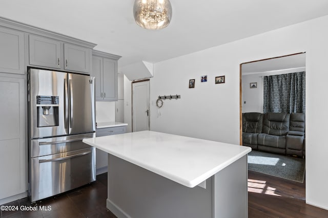 kitchen with gray cabinetry, stainless steel refrigerator with ice dispenser, dark hardwood / wood-style floors, and a kitchen island