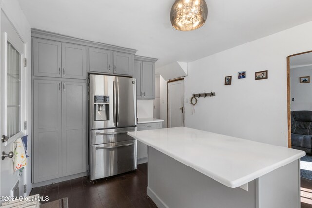 kitchen with gray cabinets, stainless steel fridge, a center island, and dark hardwood / wood-style floors