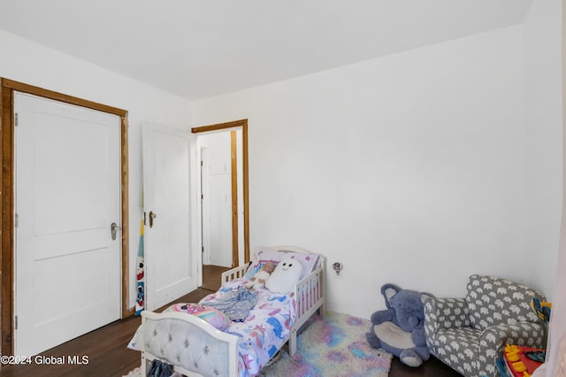 bedroom with dark hardwood / wood-style flooring