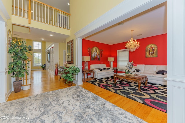 living room with hardwood / wood-style floors, a chandelier, and decorative columns