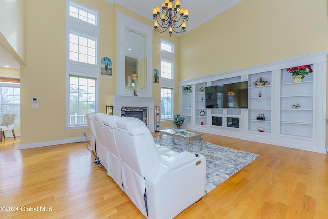 5 Teasdale Ct, Colonie, NY 12189 - living room featuring crown molding, light wood finished floors, a fireplace, a chandelier, and a towering ceiling
