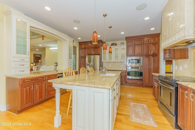 5 Teasdale Ct, Colonie, NY 12189 - kitchen with a breakfast bar area, custom range hood, a sink, stainless steel appliances, and light wood-style flooring