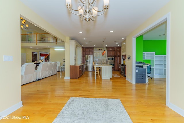 living room with light hardwood / wood-style floors and an inviting chandelier