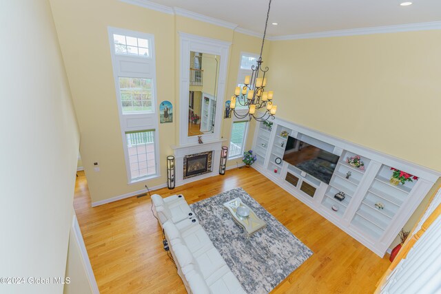 5 Teasdale Ct, Colonie, NY 12189 - living room featuring a notable chandelier, a glass covered fireplace, a healthy amount of sunlight, and wood finished floors