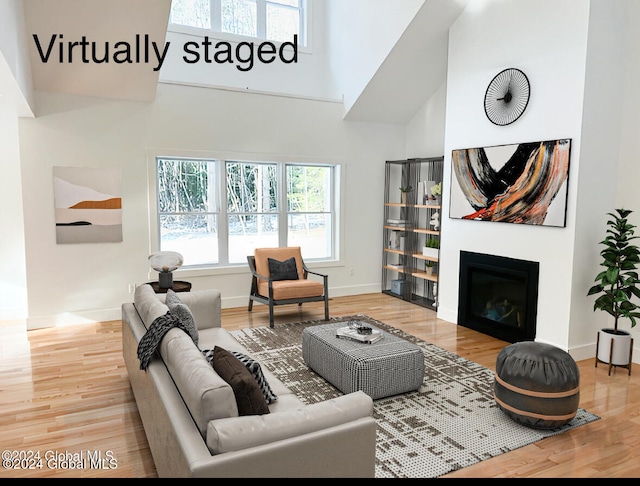 living room with wood-type flooring and a high ceiling