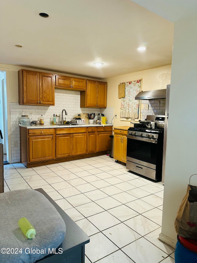 kitchen with sink, stainless steel range, decorative backsplash, and extractor fan