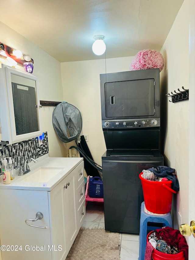 laundry room featuring stacked washer / dryer, light tile patterned flooring, and sink