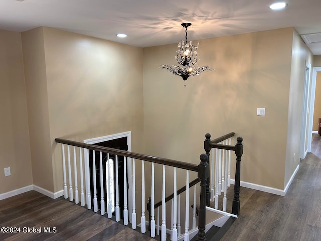 stairs with hardwood / wood-style floors and a chandelier