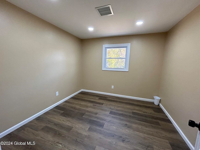 unfurnished room with dark wood-type flooring