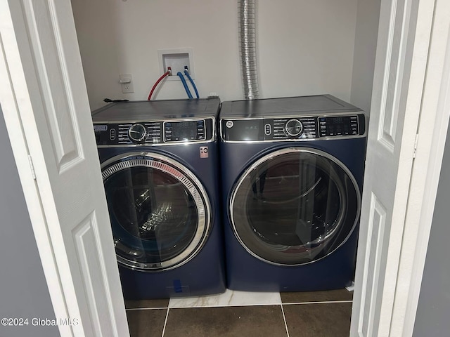 laundry room featuring washing machine and clothes dryer and dark tile patterned floors