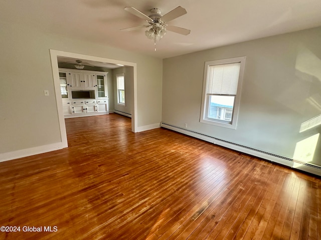 interior space featuring a wealth of natural light, hardwood / wood-style floors, a baseboard heating unit, and ceiling fan