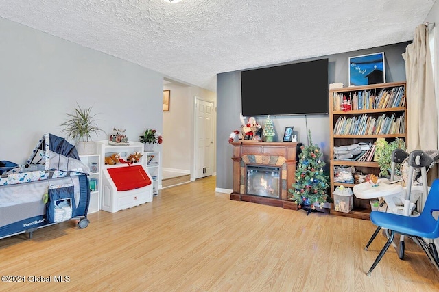 15 Windcrest Dr, Fort Edward, NY 12828 - living area featuring wood finished floors, a glass covered fireplace, and a textured ceiling