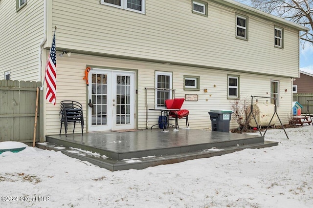 snow covered property with french doors and a wooden deck