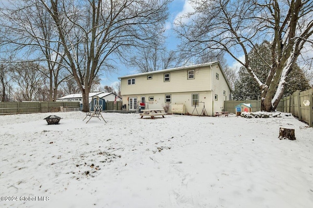 snow covered house featuring a fire pit