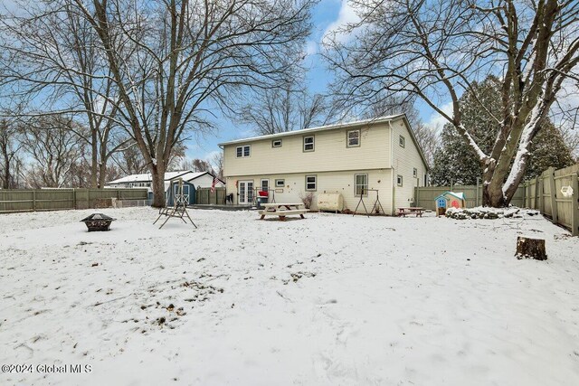 15 Windcrest Dr, Fort Edward, NY 12828 - snow covered back of property featuring an outdoor fire pit, a fenced backyard, and a shed