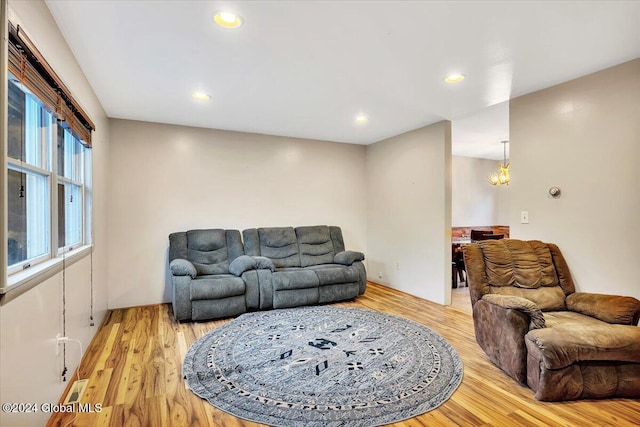 living room with light hardwood / wood-style flooring and an inviting chandelier