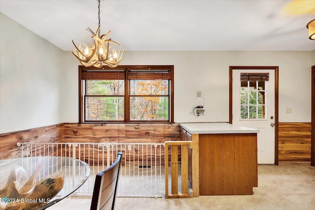 unfurnished dining area featuring an inviting chandelier and light colored carpet