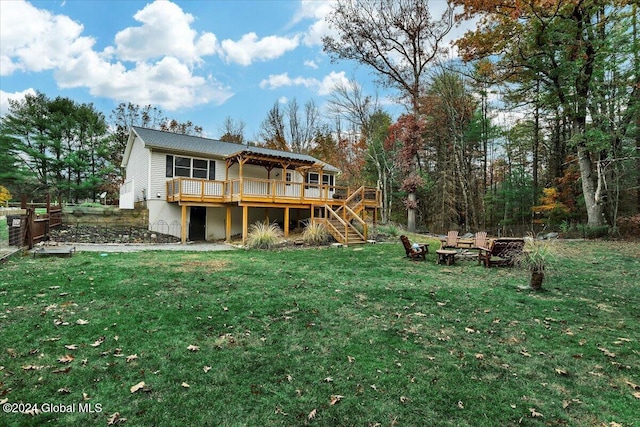 rear view of house with a deck and a lawn