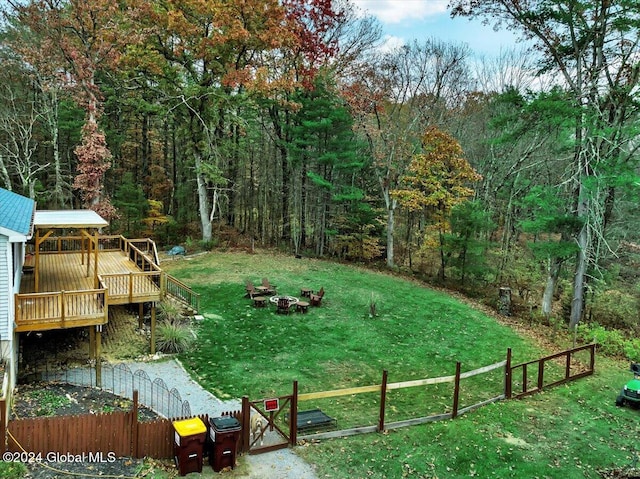 view of yard with a wooden deck and a fire pit