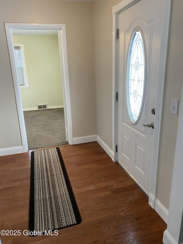 entrance foyer with wood finished floors, visible vents, and baseboards