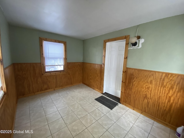 empty room with a wainscoted wall and wooden walls