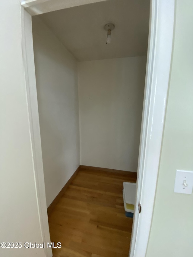 hallway featuring baseboards and wood finished floors