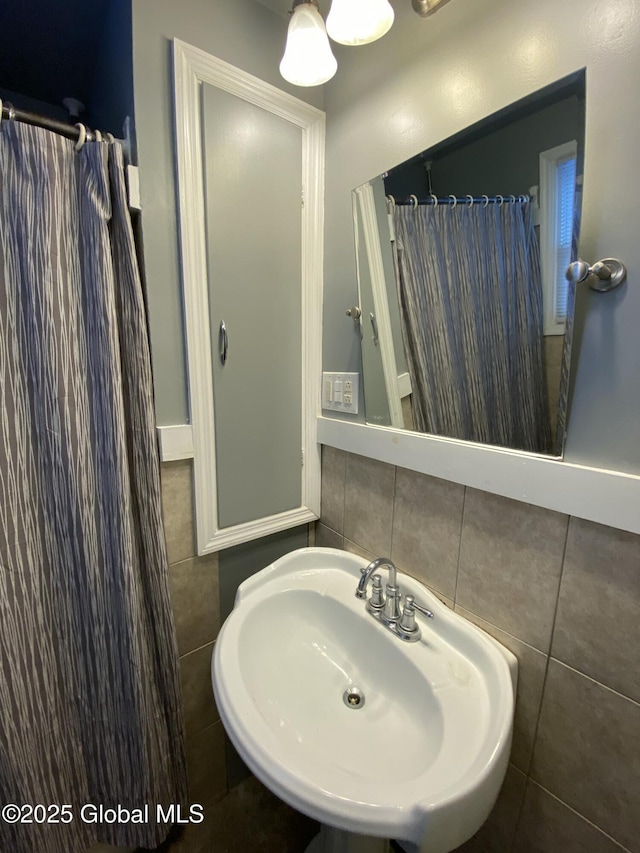 bathroom with a shower with curtain, a sink, and tile patterned floors