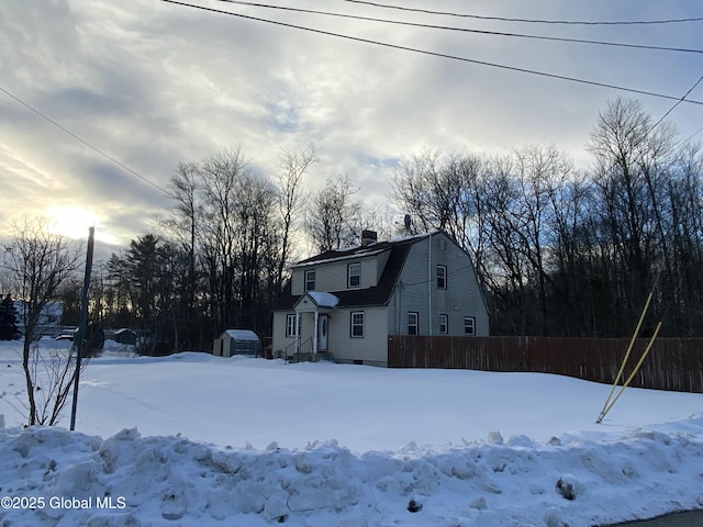 exterior space featuring fence and a gambrel roof