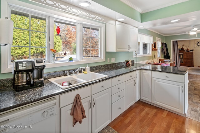 kitchen with a wealth of natural light, kitchen peninsula, and white cabinets