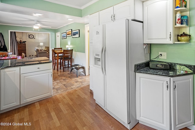 kitchen featuring light wood-type flooring, white refrigerator with ice dispenser, ceiling fan, white cabinets, and ornamental molding