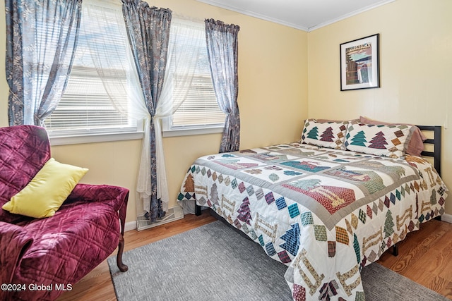 bedroom with crown molding and hardwood / wood-style flooring