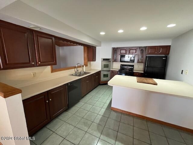 kitchen featuring dark brown cabinetry, light tile patterned floors, black appliances, and sink