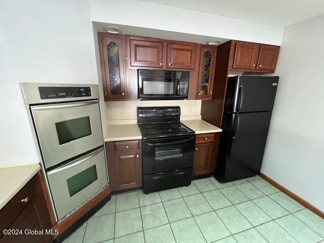 kitchen with black appliances and light tile patterned flooring