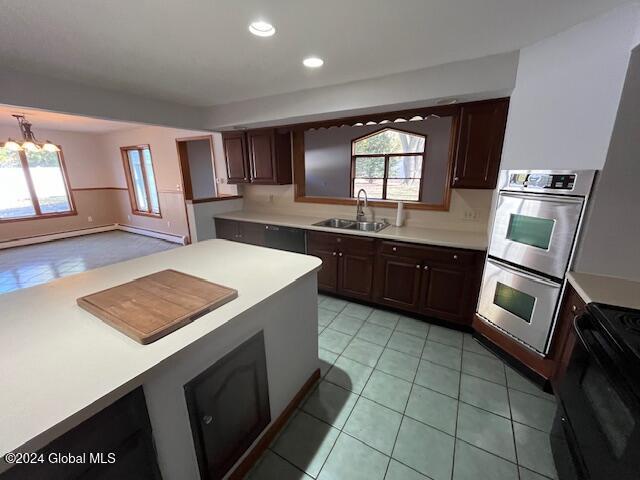 kitchen with black / electric stove, dark brown cabinetry, sink, and stainless steel double oven