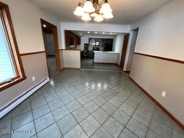 unfurnished dining area featuring a notable chandelier, a baseboard heating unit, and light tile patterned flooring