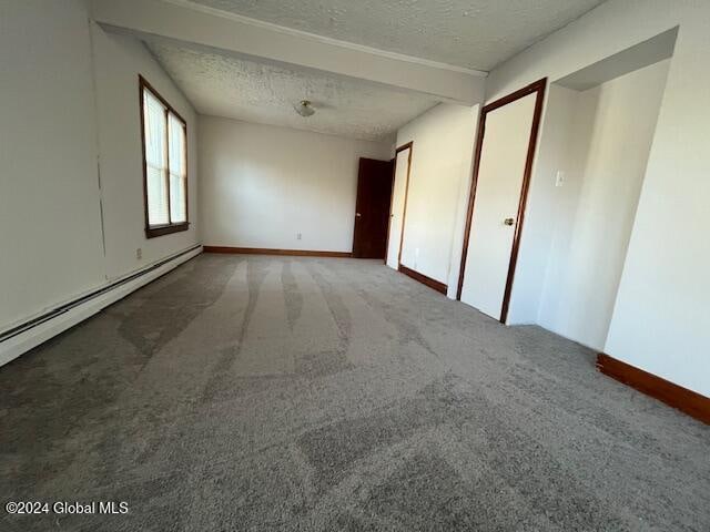 unfurnished room featuring a textured ceiling, a baseboard heating unit, and carpet