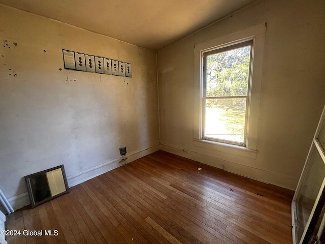 unfurnished room with hardwood / wood-style flooring and a healthy amount of sunlight