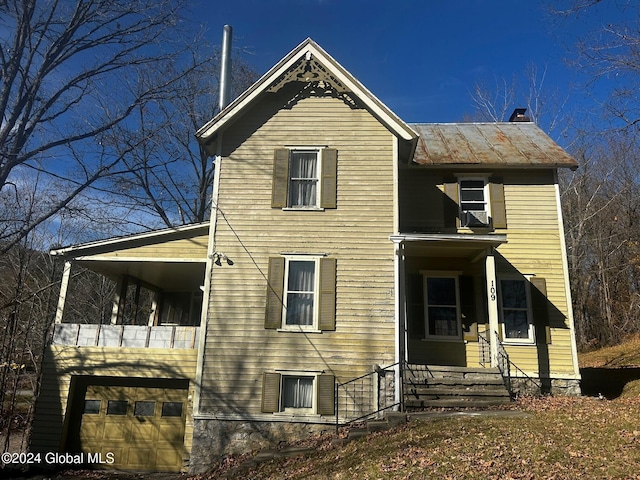 109 High St, Cobleskill, NY 12043 - rear view of house with a standing seam roof, metal roof, an attached garage, and a chimney