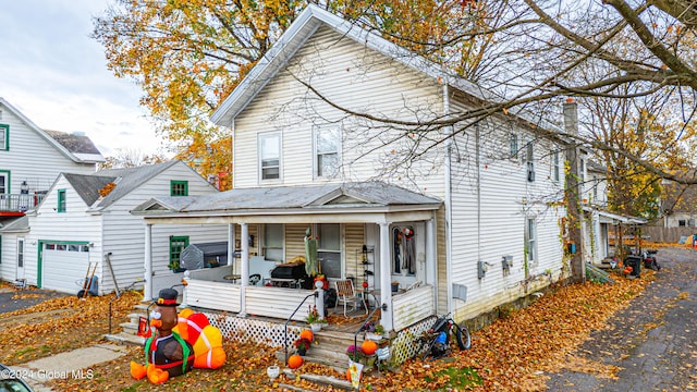 view of property with a porch and a garage