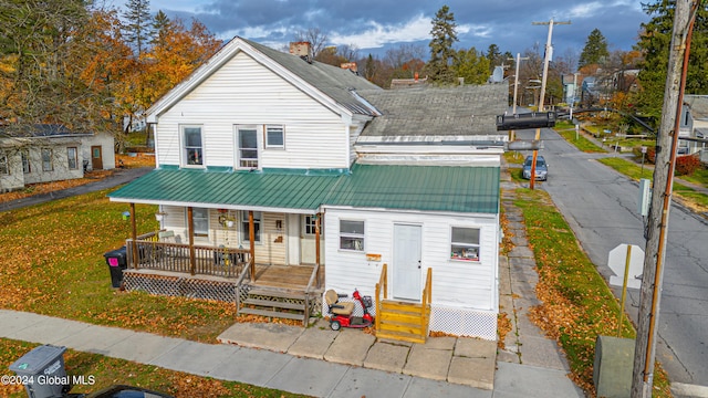 bungalow featuring covered porch and a front yard