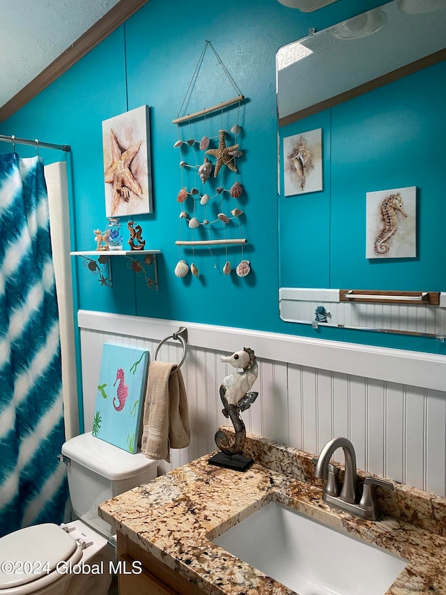 bathroom with toilet, vaulted ceiling, vanity, crown molding, and walk in shower