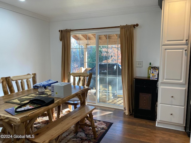 dining space with ornamental molding and dark hardwood / wood-style flooring