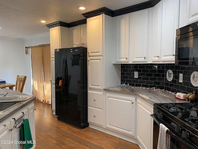 kitchen featuring white cabinetry, hardwood / wood-style flooring, and black appliances