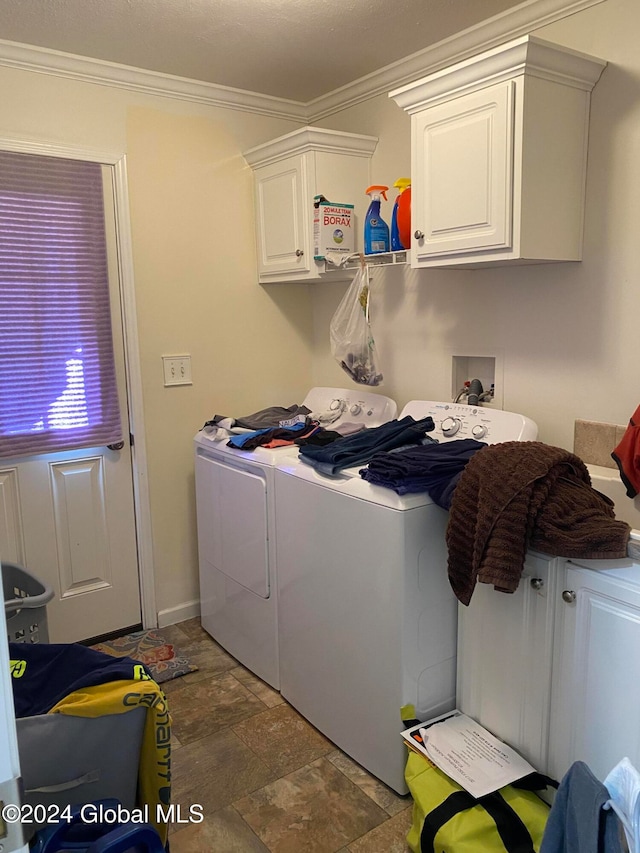 laundry room featuring ornamental molding, washer and dryer, and cabinets