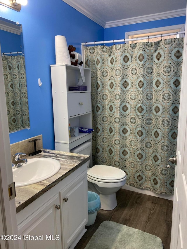 bathroom featuring toilet, wood-type flooring, ornamental molding, vanity, and a textured ceiling